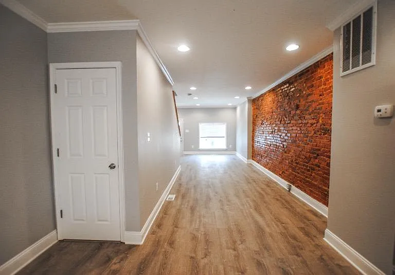 Walk in to an open first level with exposed brick in the living space
