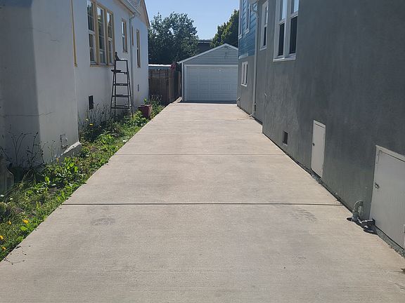 long driveway room for several vehicles with garage in the background