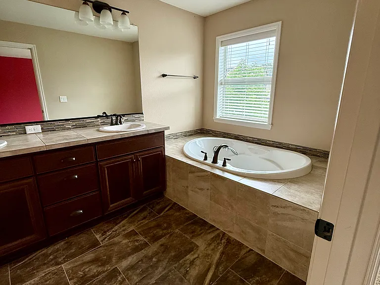 Master bathroom with dual sinks and bathtub