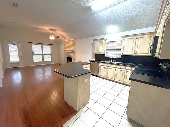 Open kitchen, dining, family room with new stainless range & dishwasher.