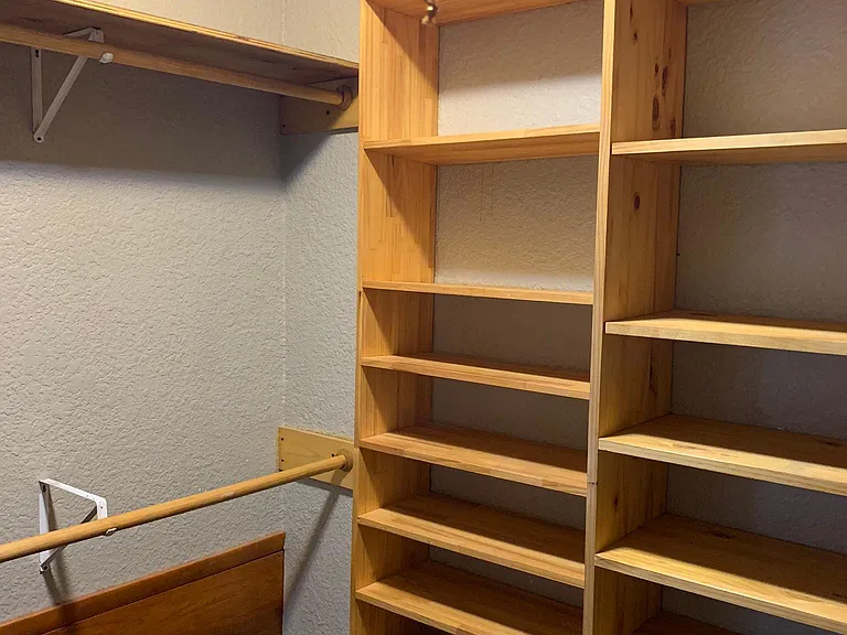 Walk-in closet in main bedroom. There are also hanging rods on two other walls of the closet.