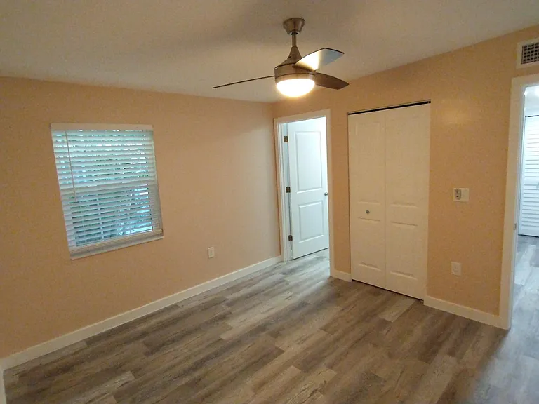 Primary bedroom with back yard view of palms