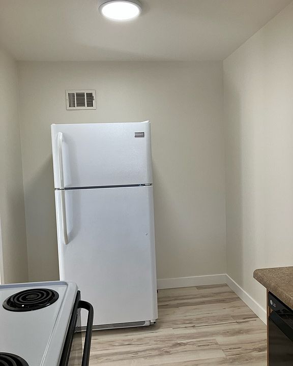 Kitchen has space for small table and chairs next to refrigerator.