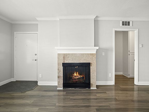 Tiled fireplace in hardwood floored living room.