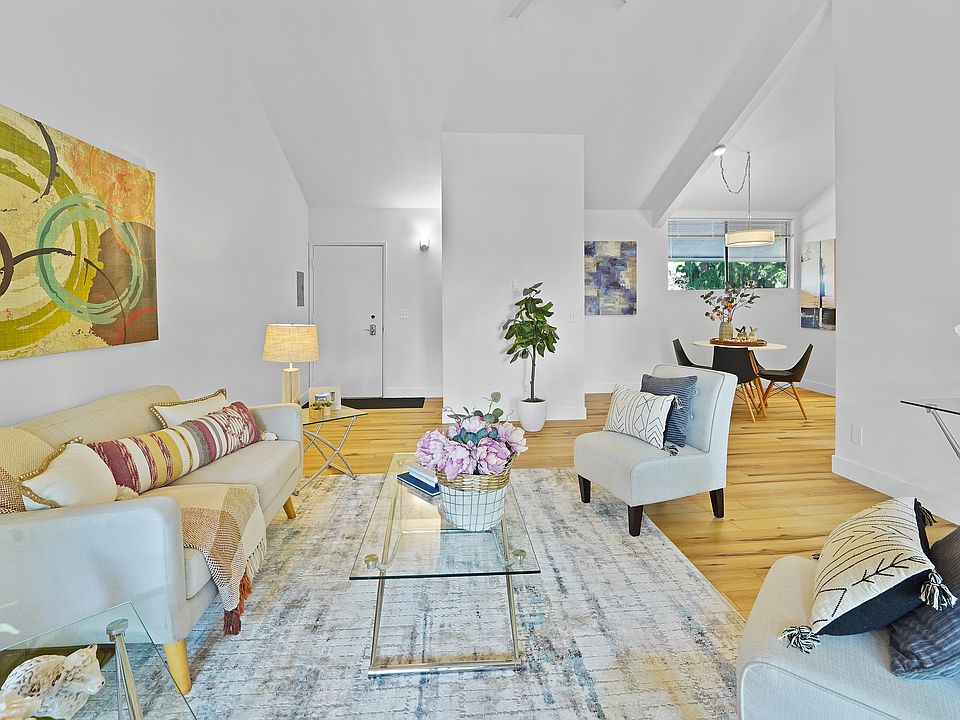 View of the living area from the floor to ceiling windows that lead to the balcony. Vaulted ceilings with a new fan with remote control