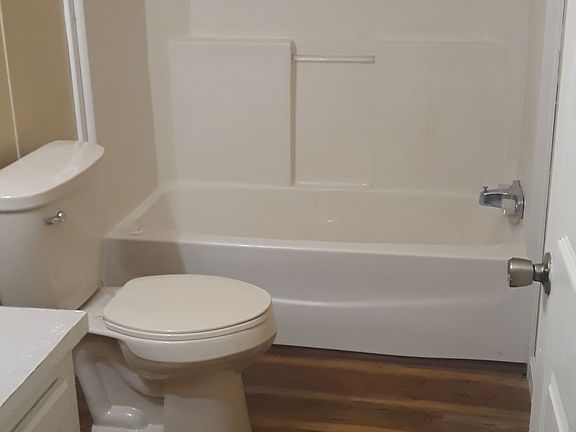 Hallway bathroom with tub and shower.