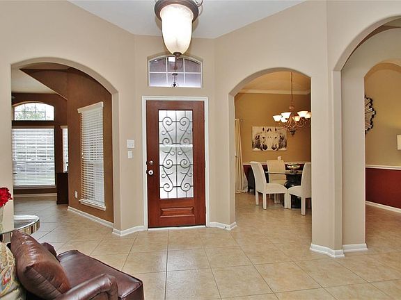 Beautiful architecture accents the foyer with doorways to the dining room and study. Note the neutral colors and tile floors.
