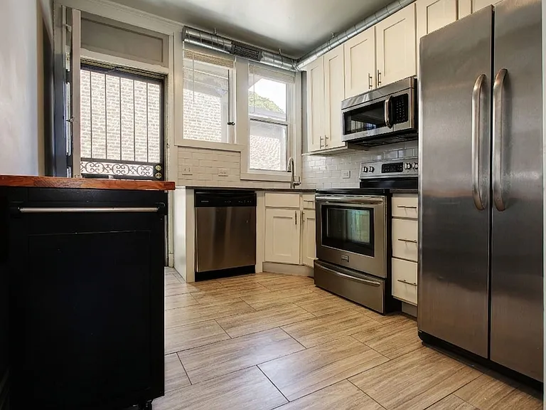 Well appointed kitchen with stainless steel appliances and plenty of cabinets. Rear exit to outdoor north back stairway.