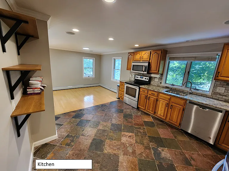 View from kitchen into dining area. Extra open shelving.