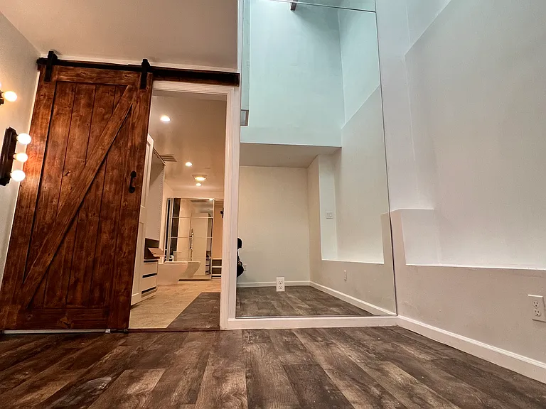 high ceiling with natural sky light and floor to ceiling mirror