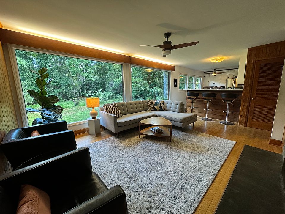 Living room with floor to ceiling windows looking out to private back yard