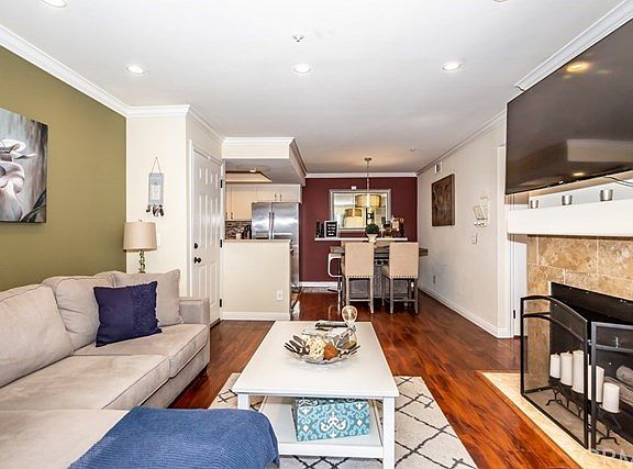 Open living room with tile fireplace and recessed lighting.