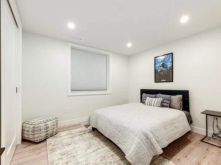 5th bedroom is on the lower level with a queen-size bed and blackout shade.