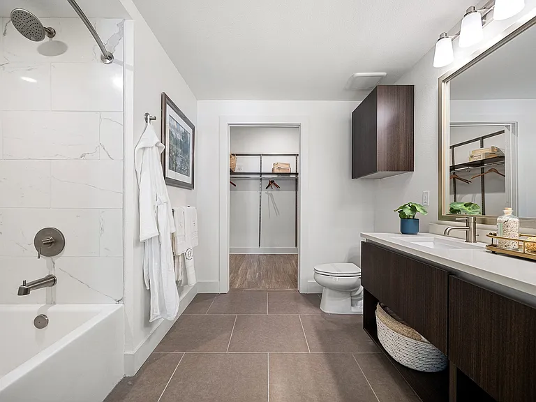 Bathroom with dual vanity, soaking tub, and walk-in closet