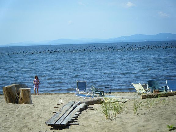 View of beach from deck, NY state across lake.