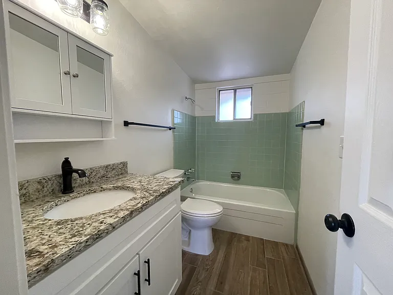 Hallway Bathroom w/ bathtub and granite vanity