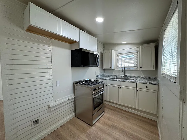 Updated kitchen with stainless steel range, microwave hood, and stainless steel refrigerator (installed since photo was taken). New windows, countertop, and flooring.
