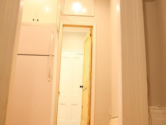 View of Doorway to Bathroom off of Kitchen. The natural Pine door is in the Bathroom.