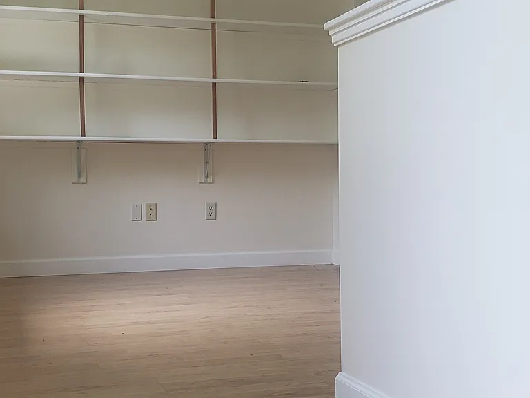 Loft with shelves at top of stairs.