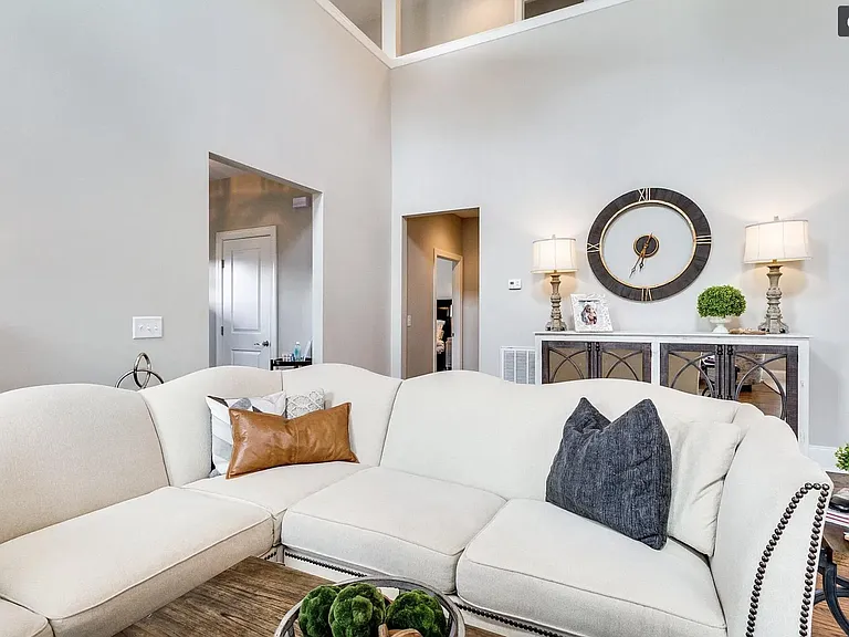 Spacious living room adjacent to hall leading to guest half bath, laundry room and attached 2-car garage