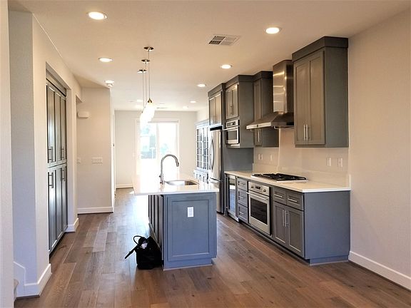 Chef's Kitchen with gas cooktop, microwave, large refrigerator, range and wine cooler with dining area by the window