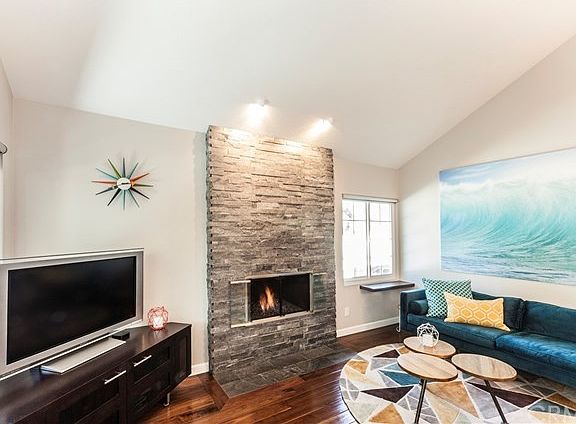 Gas & wood fireplace w/custom stone, SS glass folding doors and glass rock.