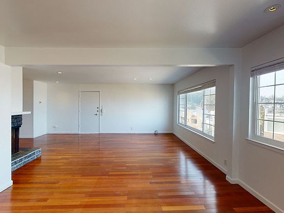 Living area with two large windows and wood-like flooring
