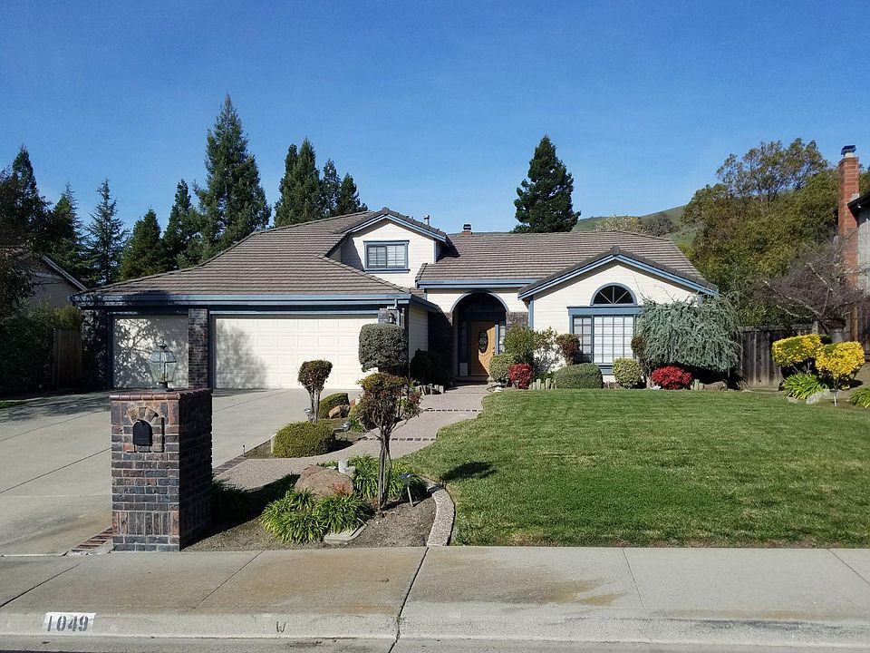 3 car garage with large manicured front lawn