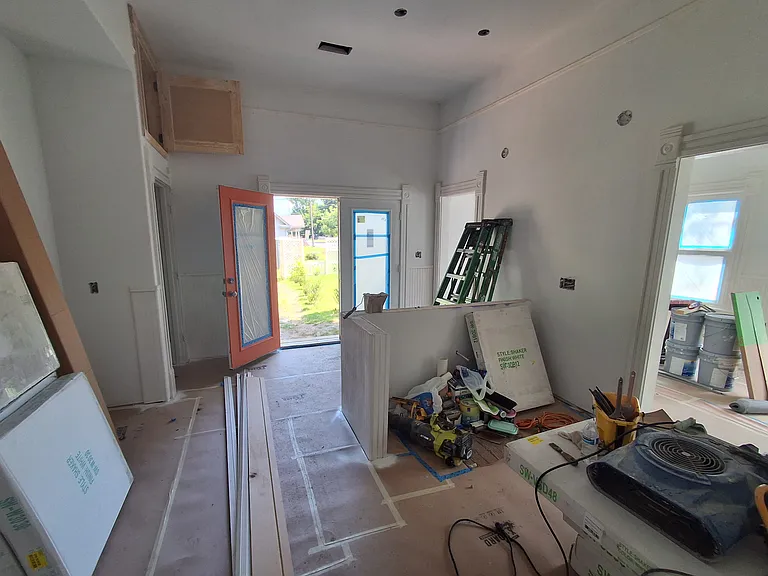Large kitchen overlooking rear garden through double French doors. Good white cabinets with vintage red pulls will be used. Of course, all new appliances. This with the beadboard primed.