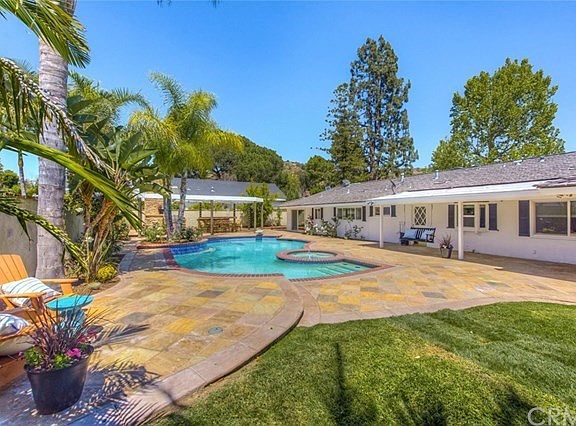 Cabana, pool, spa and grassy backyard.