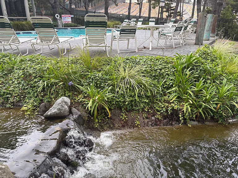 a view of sun lounger elevated over one of the many flowing water features located throughout the complex