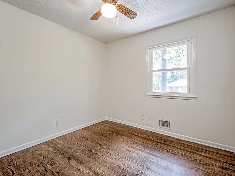 Bedroom1 upstairs featuring ceiling fan + light, window overlooking driveway + front yard