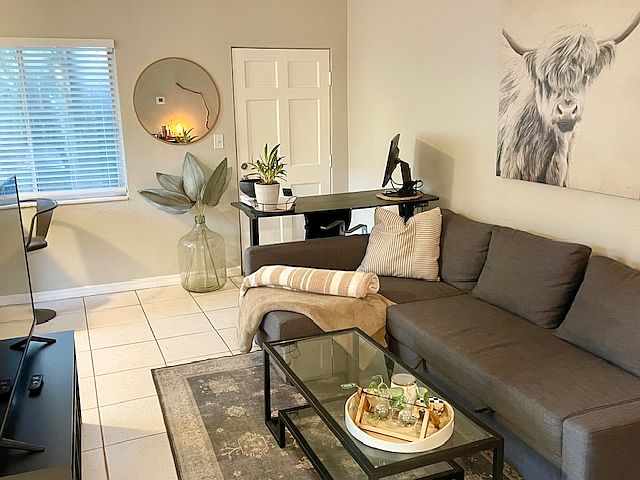 living room (furniture not included). Shows expansive front window in front of unit.