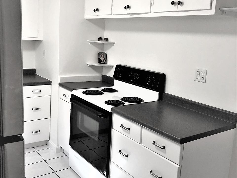 View of the other side of the kitchen area. Many cabinets and drawers and shelves.