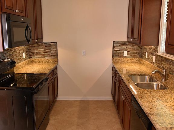 Granite counters, cherry cabinets, glass tile backsplash, porcelain tile floors, LED under-cabinet lights