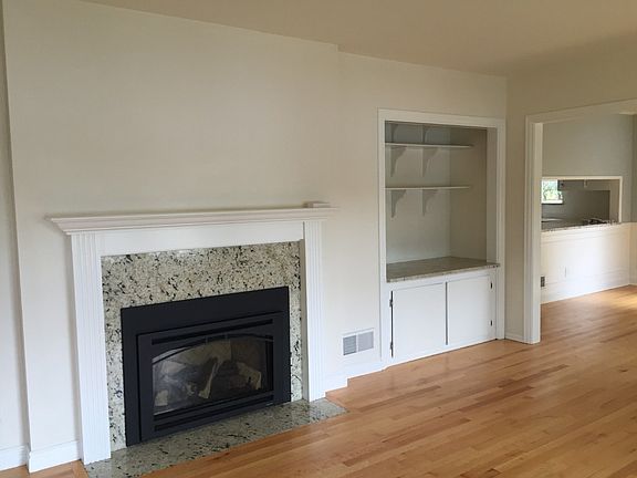 living room fireplace, dining and kitchen in the right of the photo