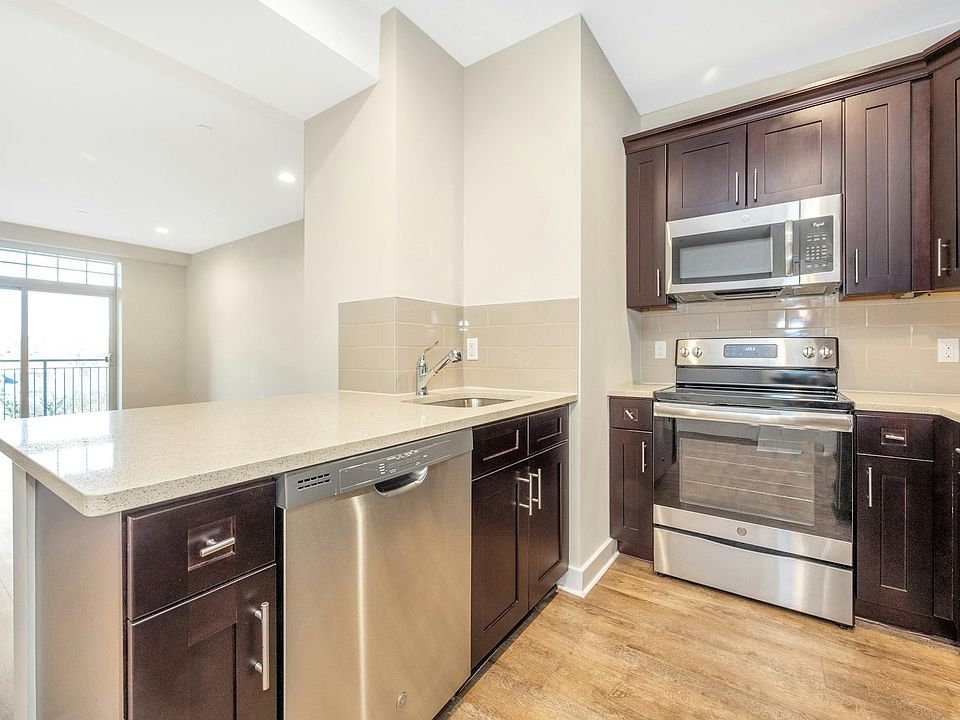 Welcome to 40 Jackson 1F. Kitchen with Stainless Steel Appliances & Quartz Countertops Open to Living Room.