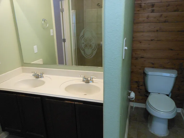 Primary bath with Dual vanity with shower in background.