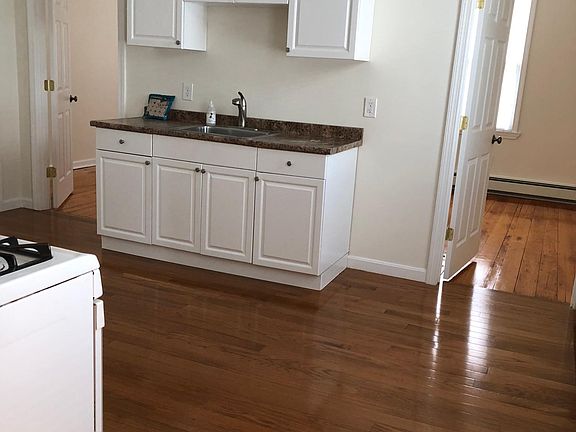 This view of the large kitchen shows both bedroom entrances on either side of the cabinet sink off of the kitchen.