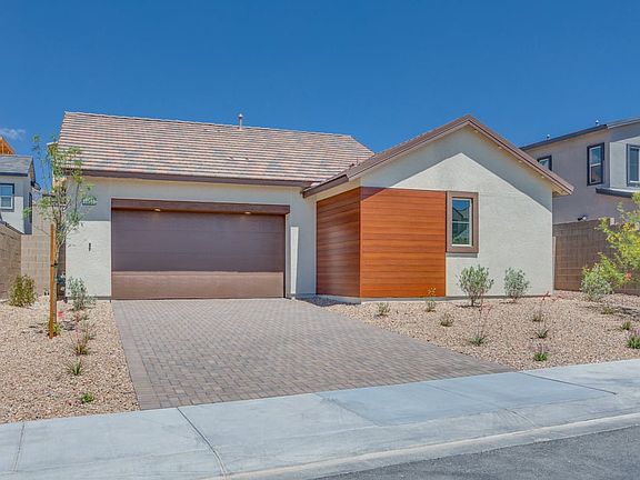 A modern, single-story house with a garage, featuring a mix of stucco and wood siding, set against a
