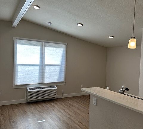 View from the entrance-room for bar stools at the counter. Lofted ceiling and great natural light