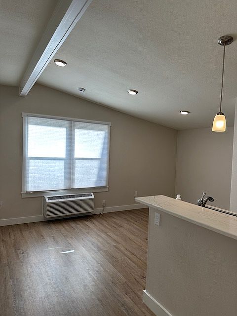 View from the entrance-room for bar stools at the counter. Lofted ceiling and great natural light
