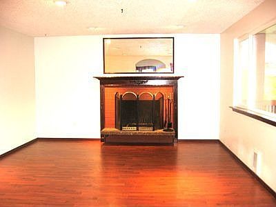 Living room with wood burning fireplace and mantel