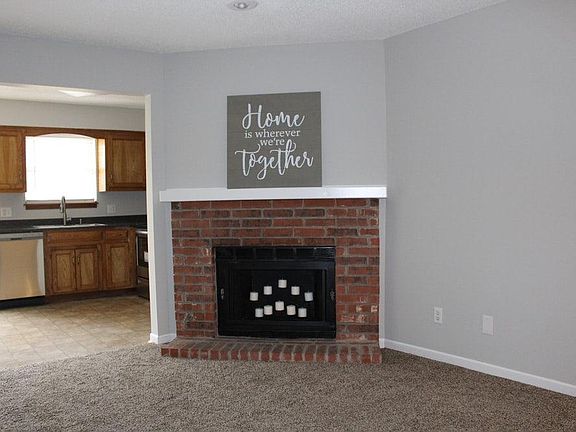 LIVING ROOM. New carpet. Newly painted walls/trim. Non-working fireplace.