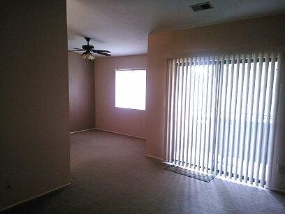Living room, dining room with ceiling fan, and sliding door to balcony