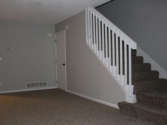 LIVING ROOM. Stairs to 2nd level. New carpet. Newly painted walls/trim/doors.