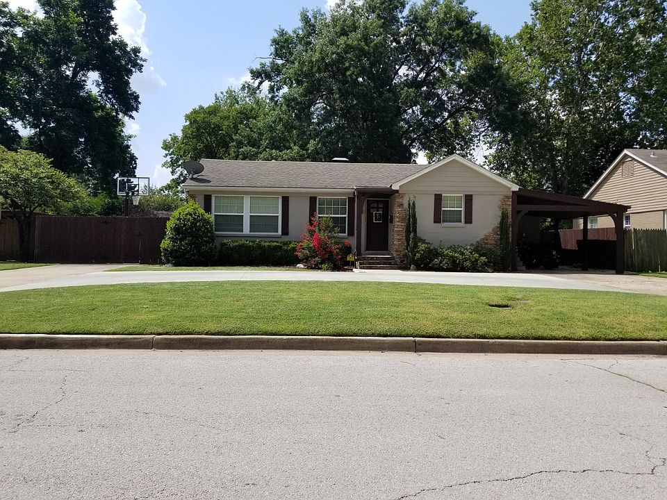 Front of house, car port to the right.