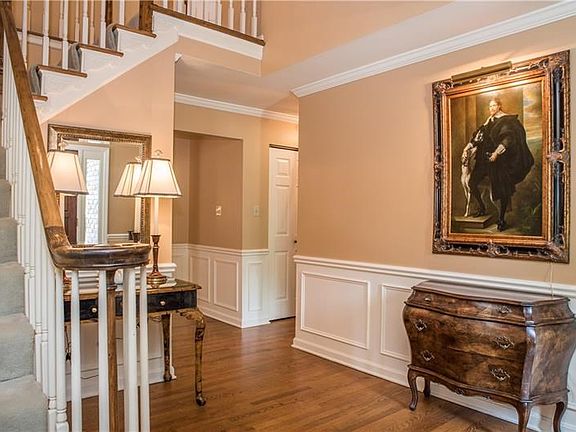 The turned staircase in the foyer features intricate detail on the steps and a traditional bull nose railing.