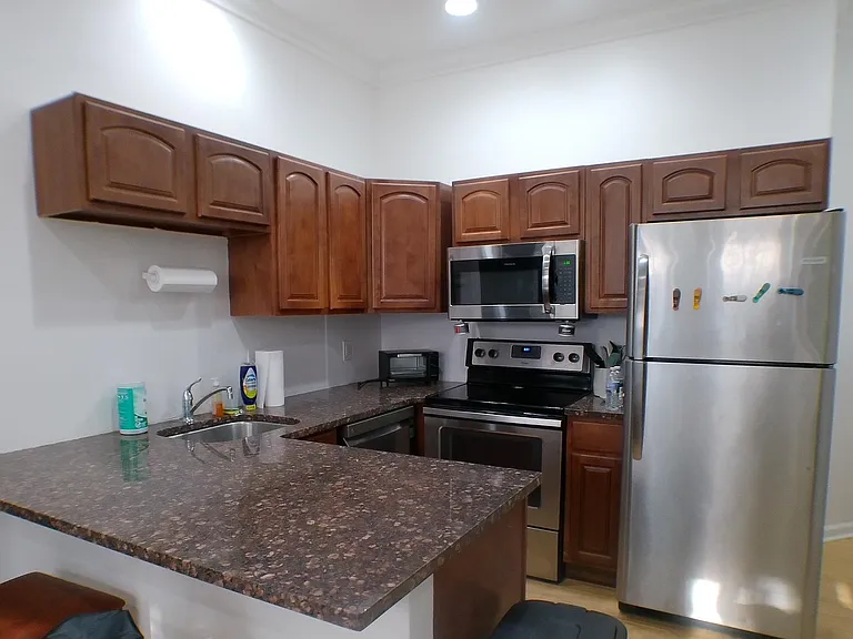 Efficient U-shaped kitchen with generous counter space, ample upper cabinetry, and stainless-steel appliance package.