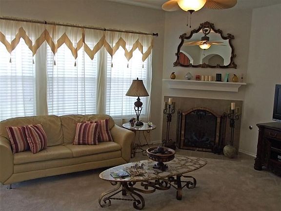 Spacious living room with fireplace, window coverings...